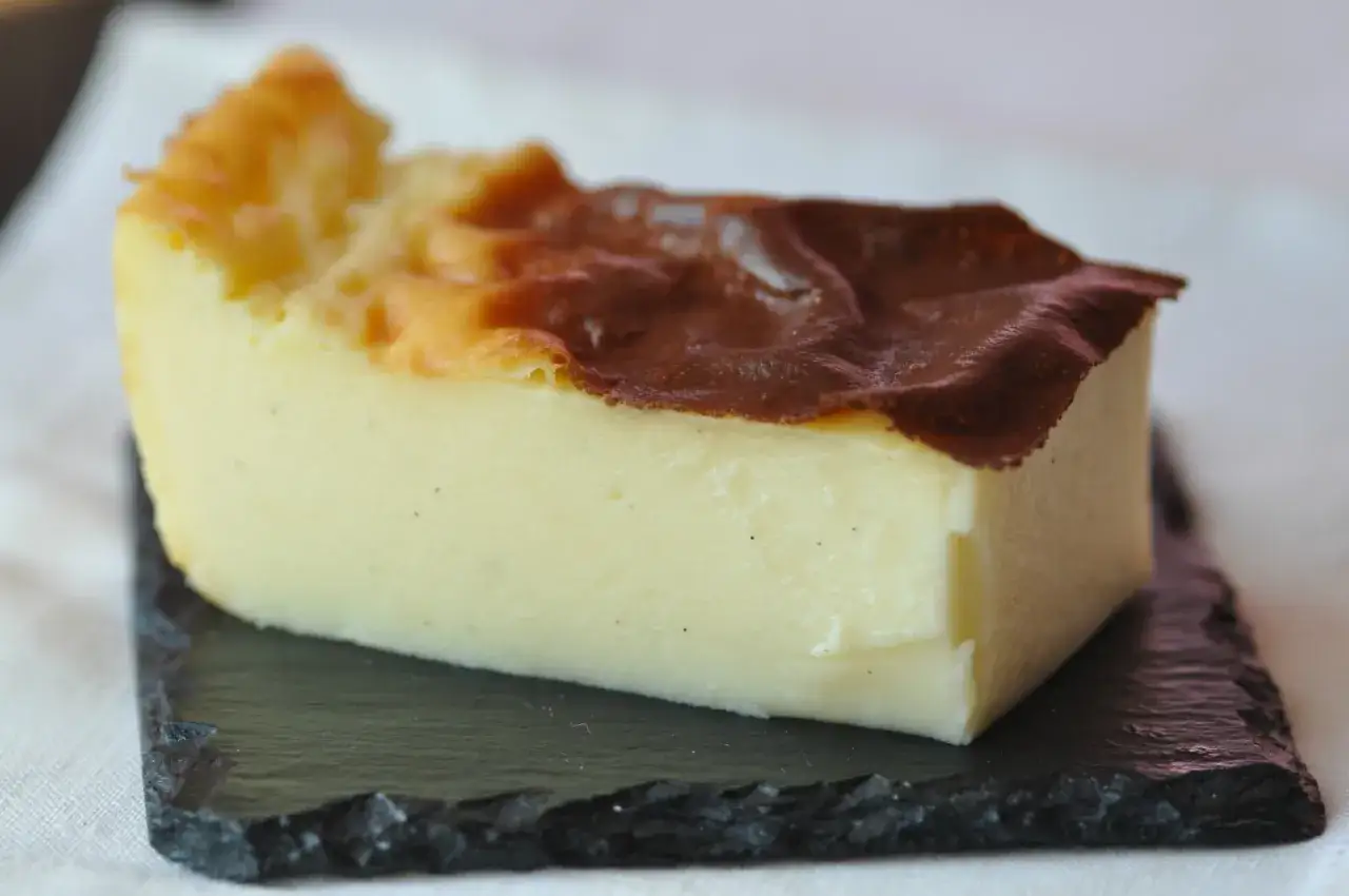 Tranche de flan pâtissier, on voit les grains de vanille dans la crème. Une recette flan sans pâte facile à réaliser pour un dessert gourmand.