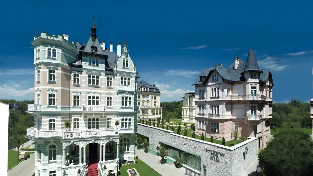 Eleganckie budynki w stylu secesyjnym, przypominające pałace, otoczone zielenią. To piękne **Karlowe Wary**, gdzie historia spotyka się z luksusem.