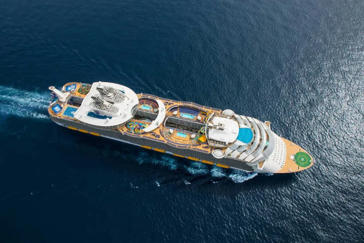 Symphony of the Seas fakta: Ett enormt kryssningsfartyg med flera pooler och aktiviteter glider fram p&aring; det m&ouml;rka havet.