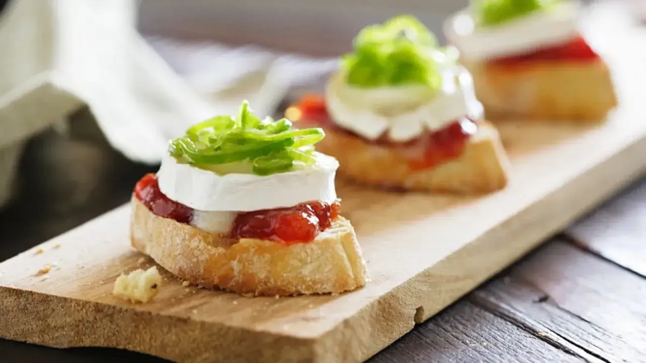 Deliciosos canapés de pan con queso de cabra, mermelada y pimiento verde. Perfectos para tus recetas para cenas con amigos.