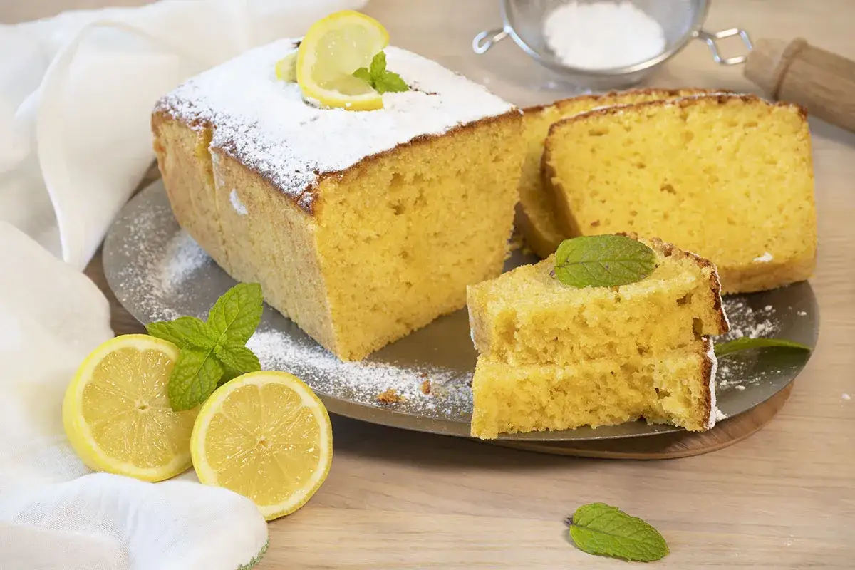 Un delicioso bizcocho de lim&oacute;n, espolvoreado con az&uacute;car glas y decorado con rodajas de lim&oacute;n y hojas de menta.