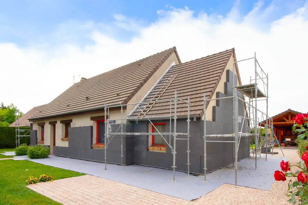 Maison en cours d'isolation par l'ext&eacute;rieur. Les inconv&eacute;nients sont visibles : &eacute;chafaudages, acc&egrave;s g&ecirc;n&eacute;, et l'aspect brut des mat&eacute;riaux.