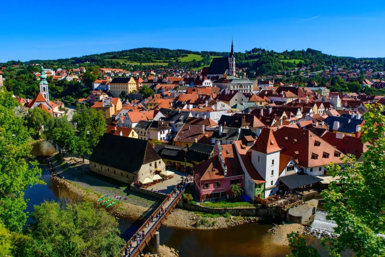 Malownicze czeskie miasteczko z czerwonymi dachami, rzeką i mostem. Idealne miejsce na wakacje w Czechach.