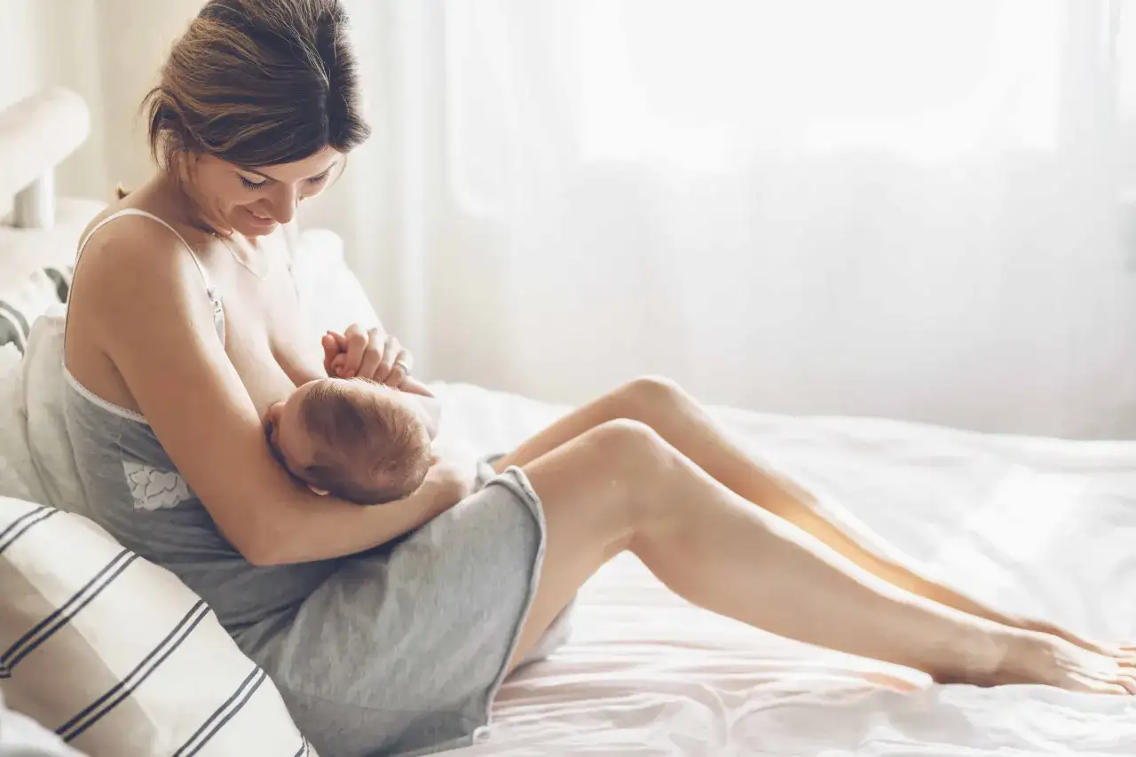Szczęśliwa mama karmiąca piersią jedząca owsiankę