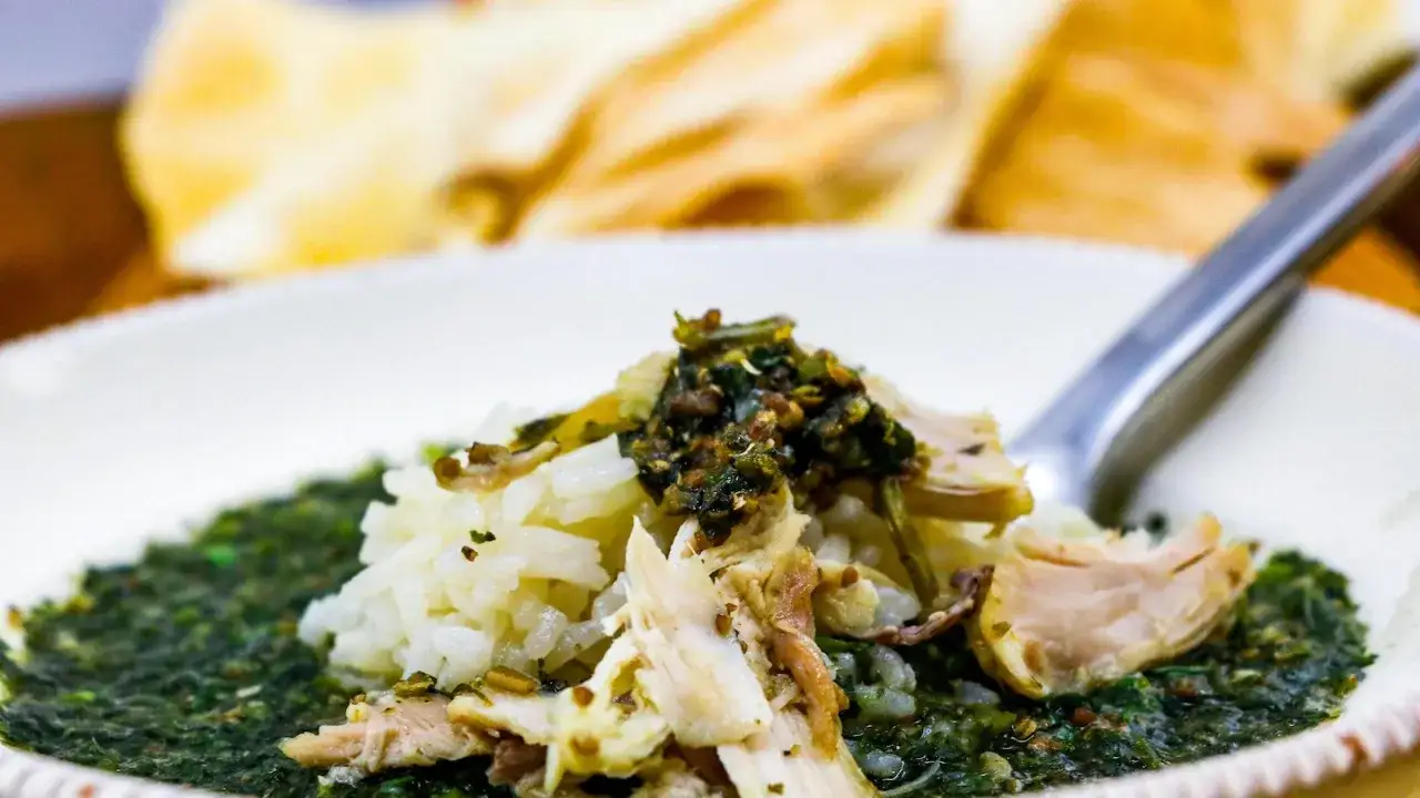 Un plat de mloukhia égyptienne savoureux avec du riz blanc et du poulet effiloché, prêt à être dégusté.