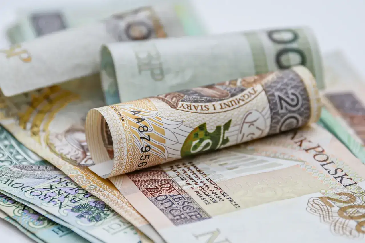 Zrolowane polskie banknoty, w tym 20 zł z wizerunkiem Sobieskiego. Tabela netto 14. emerytury może być oparta na takich nominałach.