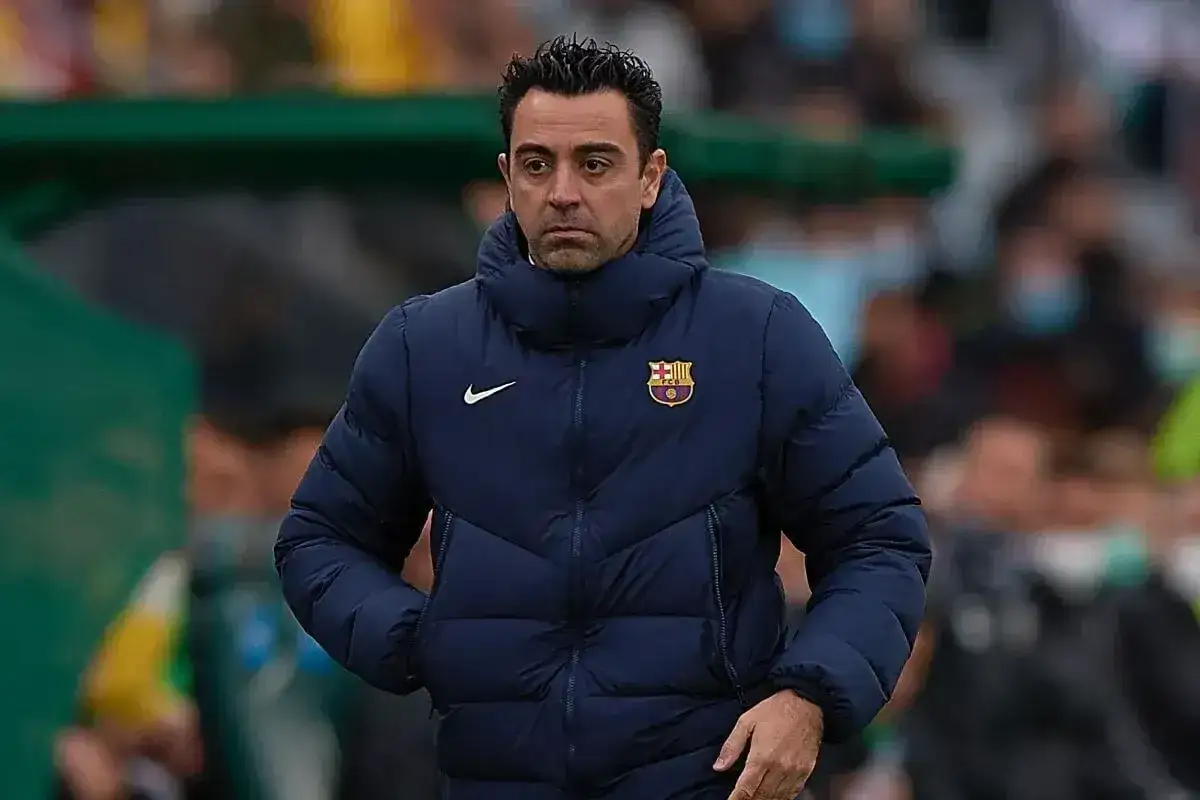 Xavi, jeden z legendarnych **barcelona trenerzy**, w puchowej kurtce z herbem klubu.