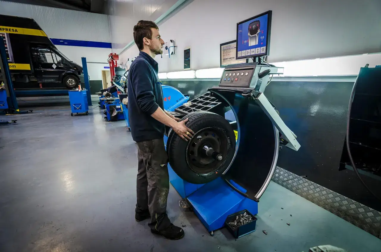 Técnico realiza el equilibrado de ruedas en un taller mecánico, asegurando un rodaje suave y seguro.