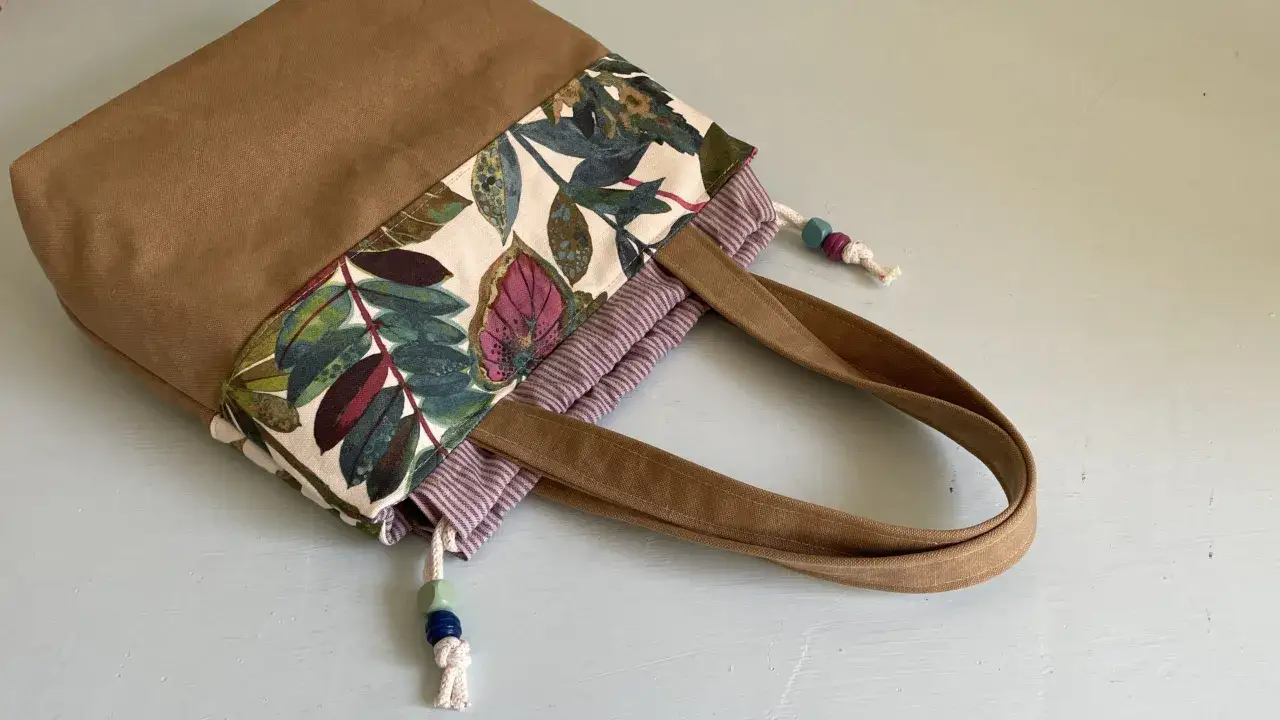 Stofftasche mit Blattmuster und braunen Henkeln. Ein kostenloses Schnittmuster Tasche mit Boden zum Selbern&auml;hen.