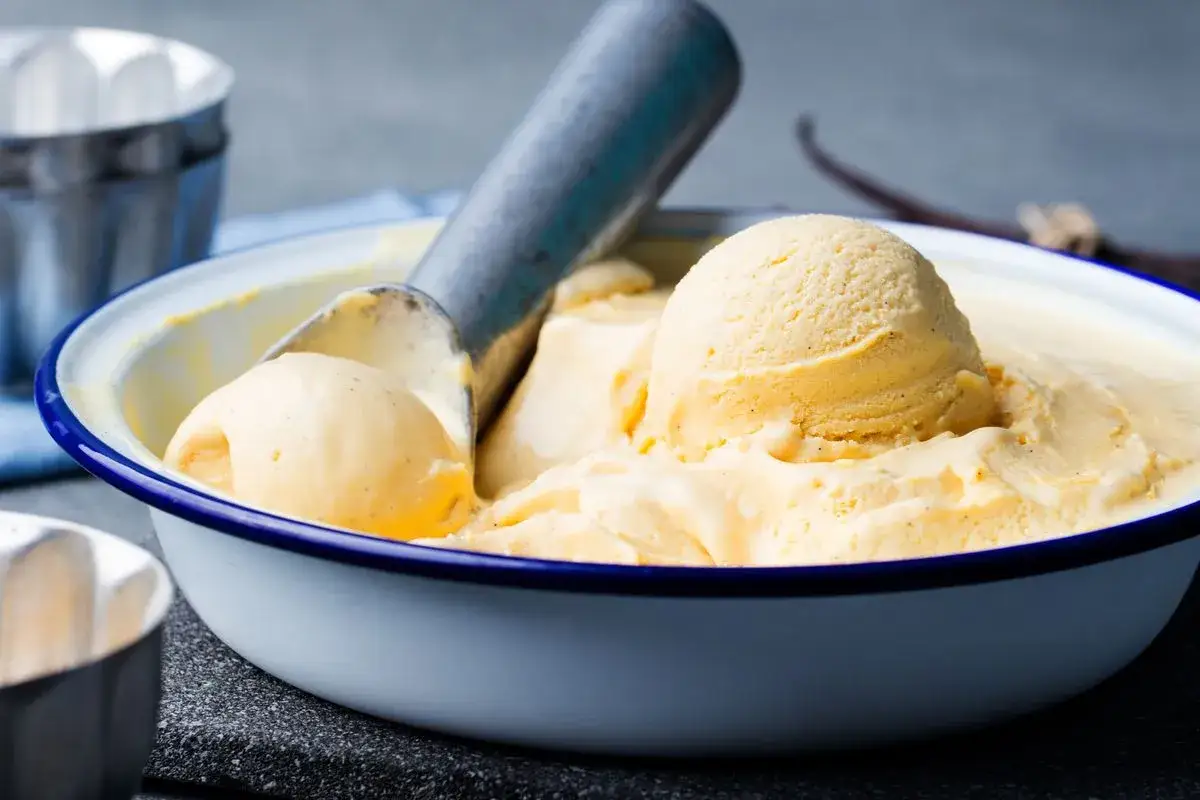Gelato alla vaniglia servito in una ciotola con palette. Un modo delizioso per servire il gelato a casa.