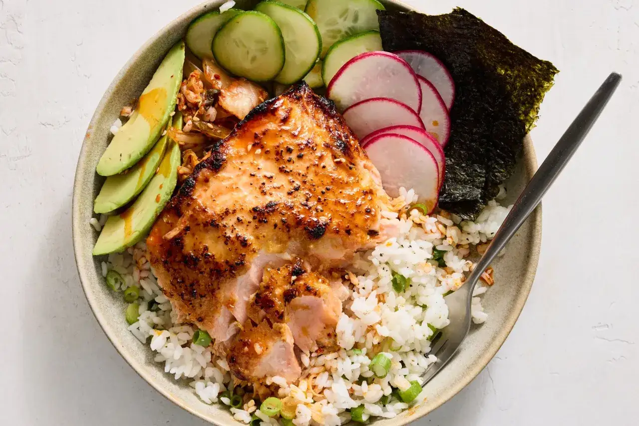 Sch&uuml;ssel mit Reis, Lachs, Avocado, Gurke, Radieschen und Nori. Ein Gericht, das zeigt, wie man gesund und lecker kochen kann.