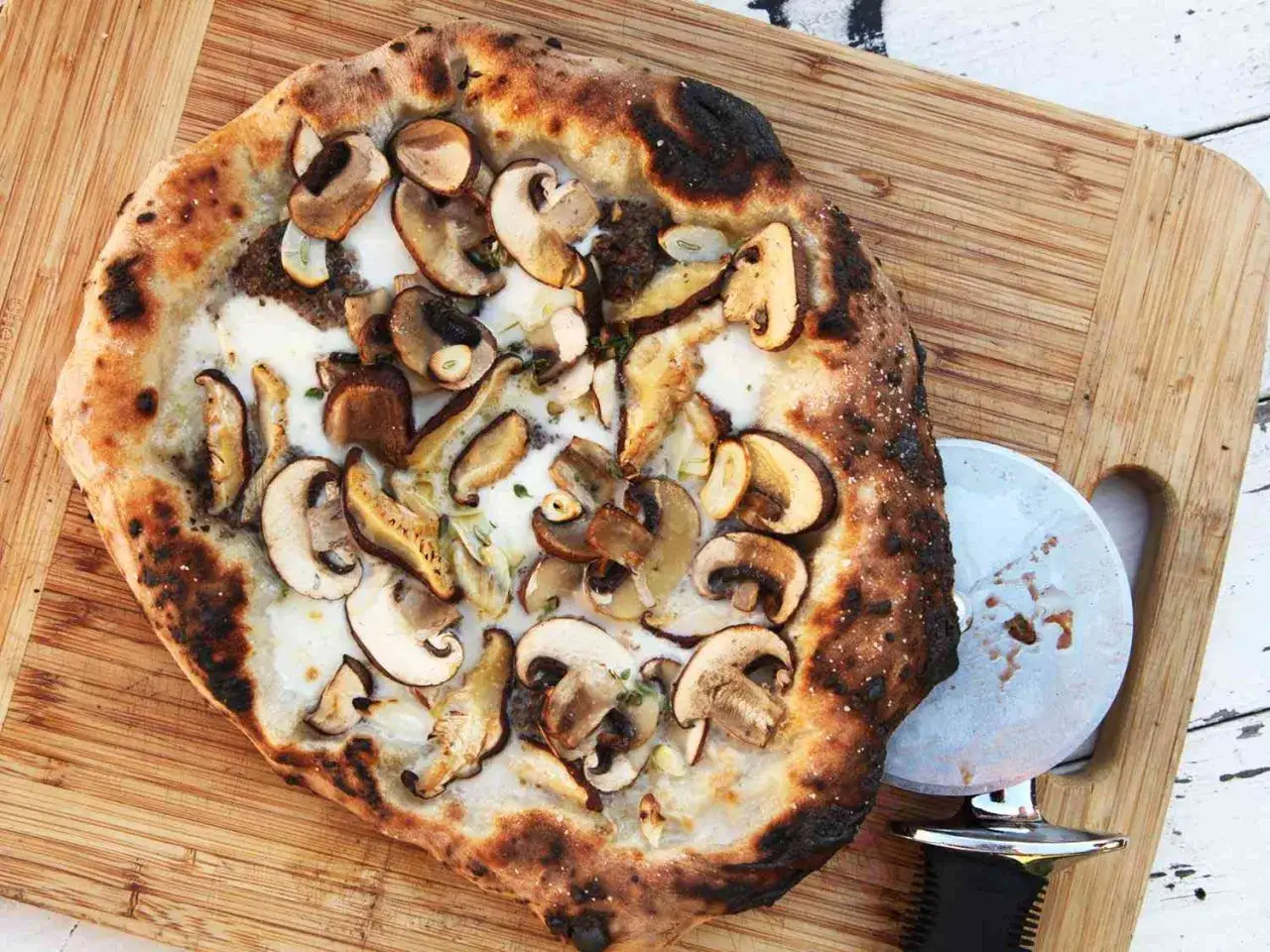 Pyszna pizza z pieczarkami do pizzy, z chrupiącym ciastem i ciągnącym się serem, gotowa do pokrojenia.