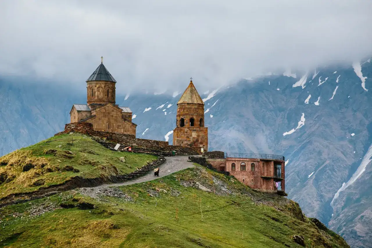 Gruzja co zobaczyć w 7 dni: Gergeti Trinity Church na tle gór. Warto odwiedzić to miejsce podczas podróży po Gruzji.