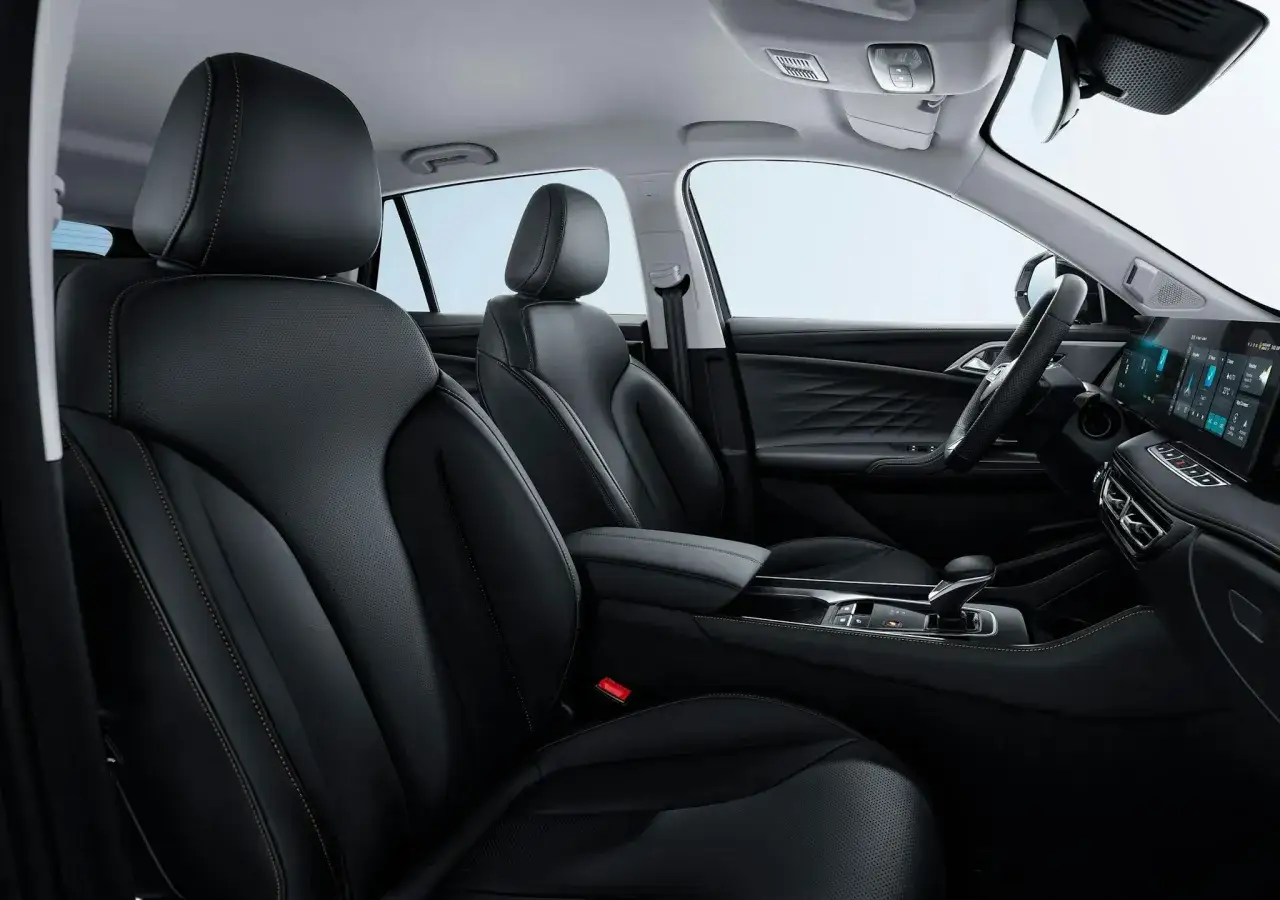 Interior de un coche con asientos de cuero negro, costuras naranjas y pantalla t&aacute;ctil. Es una prueba del mg hs.