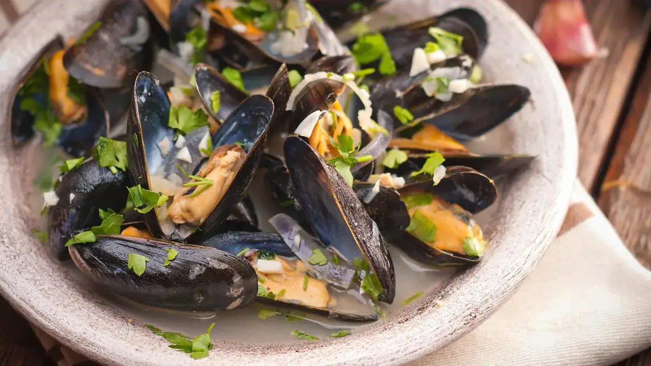 Ein Teller Moules Marini&egrave;res, dampfend und mit frischer Petersilie garniert, bereit zum Genie&szlig;en.