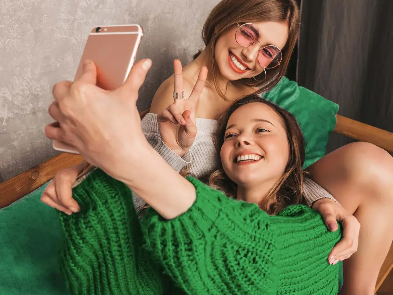 Två glada vänner tar en selfie med en mobil. Perfekt för ett Telenor familjeabonnemang för att dela stunder.