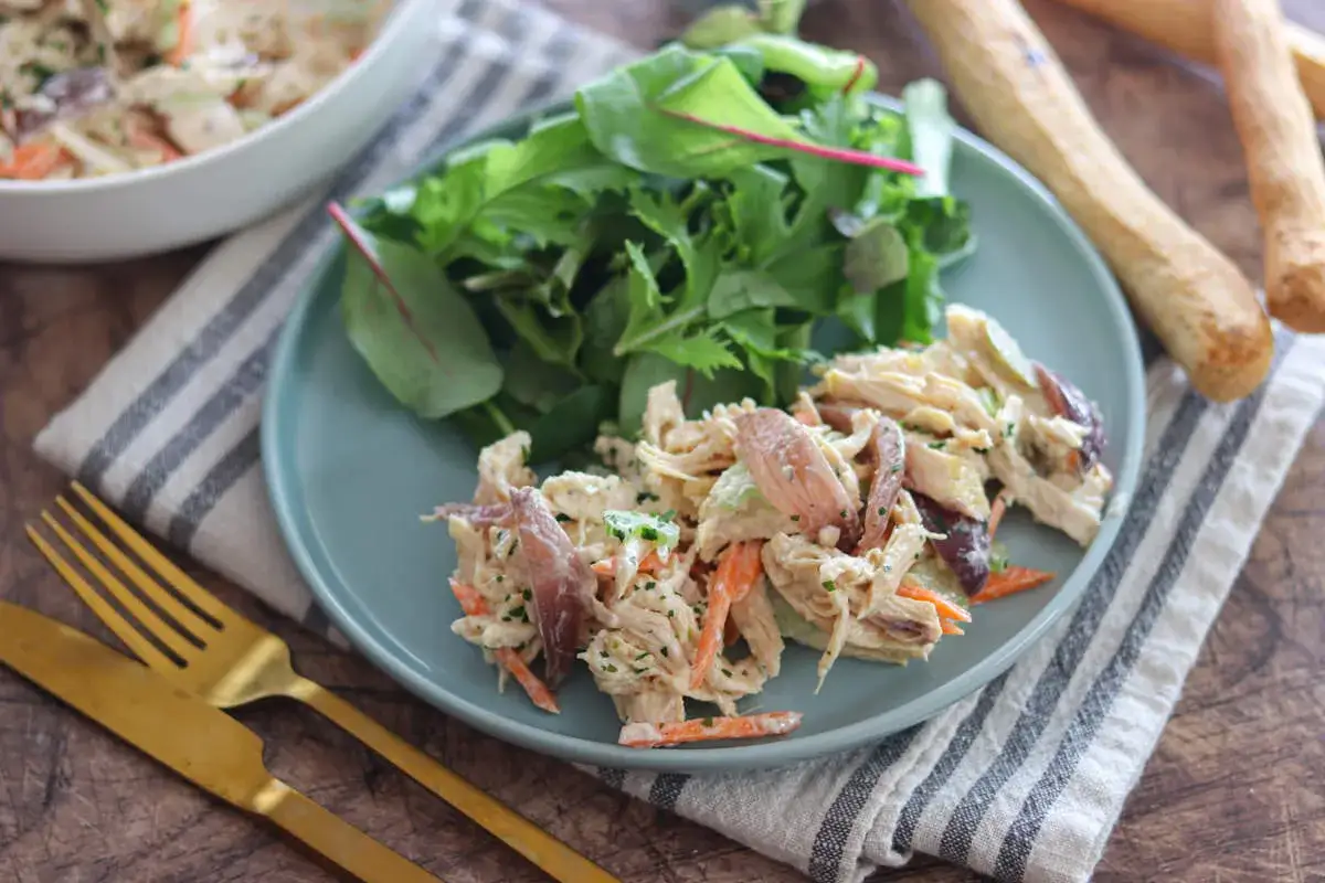Un piatto di insalata di pollo della nonna, con verdure fresche e grissini croccanti.