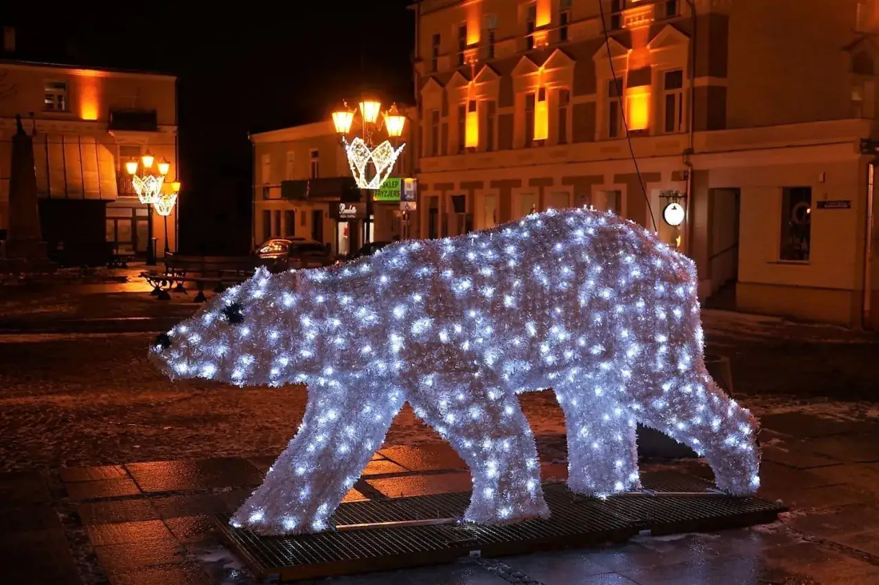 Świecący niedźwiedź, jak z legendy o Chełmie, ozdabia nocne miasto.