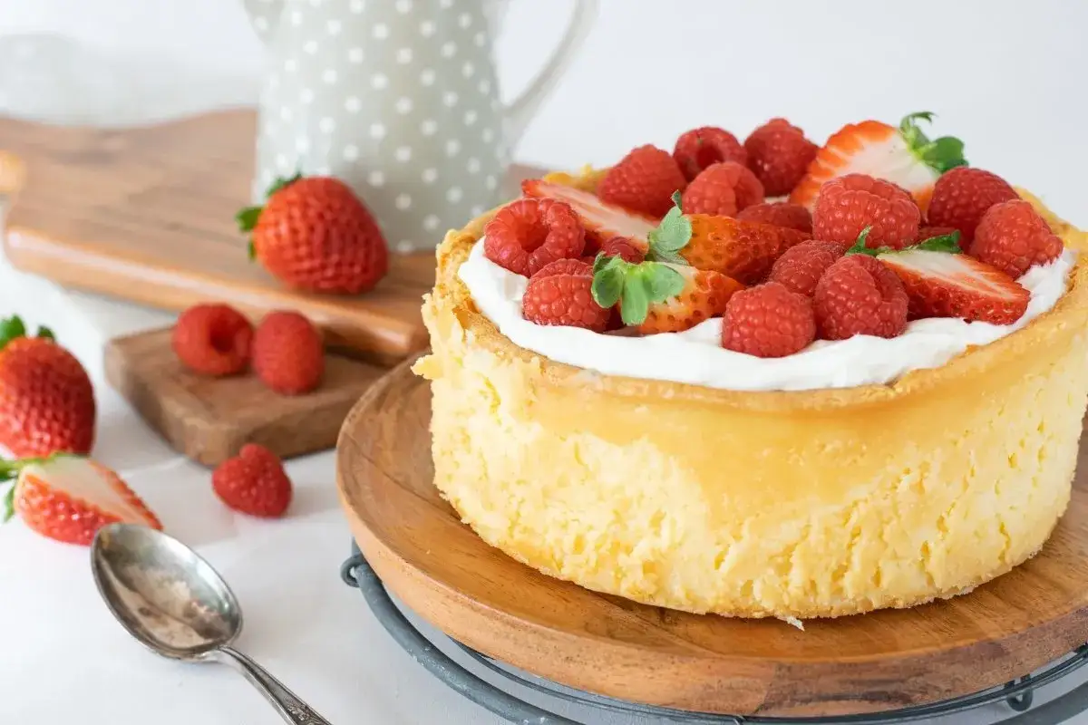 Deliciosa tarta italiana mascarpone cubierta de fresas y frambuesas frescas, lista para disfrutar.