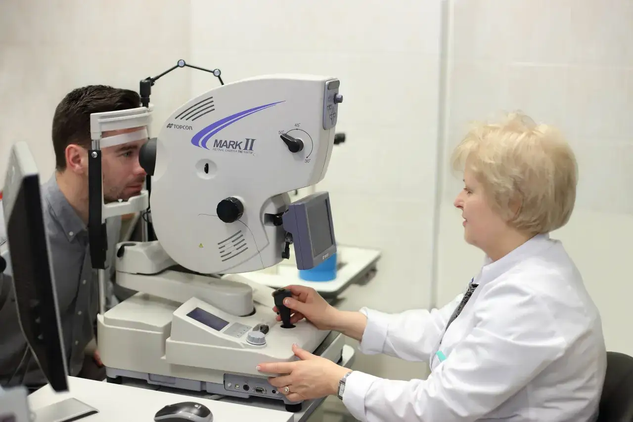 Przygotowanie do angiografii oka: lekarz wykonuje badanie pacjentowi za pomocą specjalistycznego sprzętu Topcon Mark II.