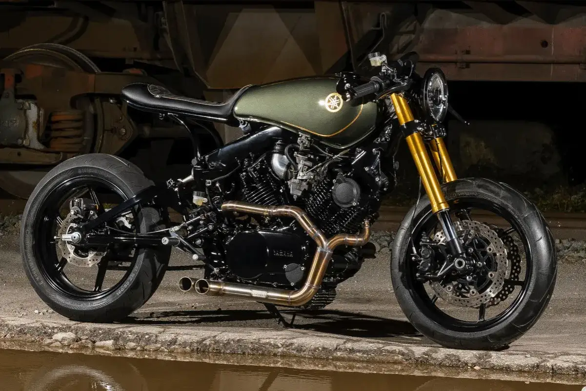 Una splendida **cafe racer custom** verde oliva con dettagli dorati, pronta per sfrecciare.