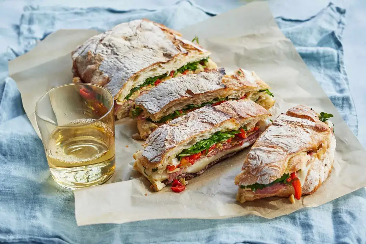 Pyszne panini, czyli chrupiące bułki z serem, wędliną, rukolą i papryką, idealne na szybki lunch.