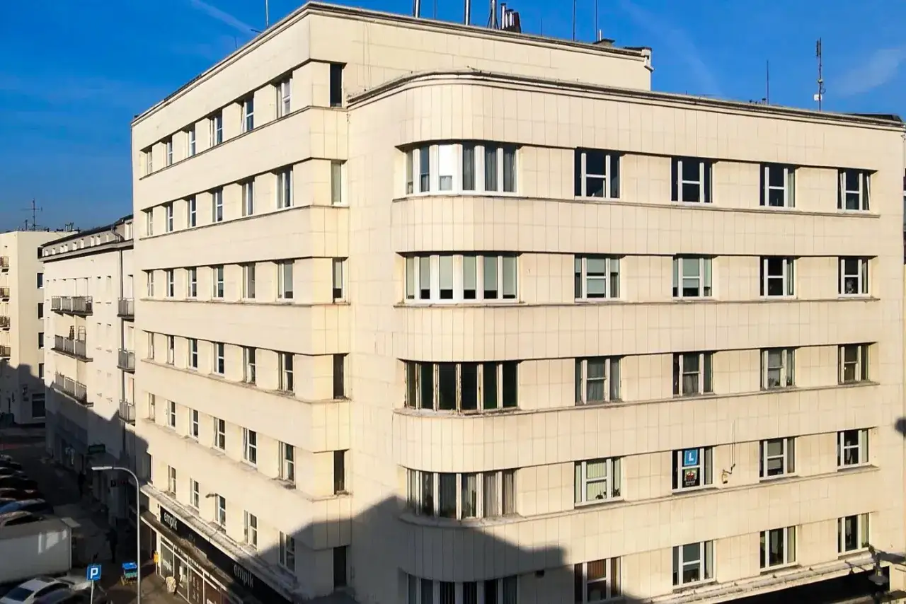 Elegancki budynek z zaokrąglonym narożnikiem, przykład modernistycznej architektury w Gdyni.