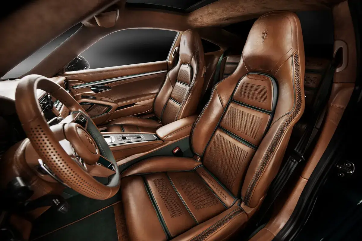 El lujoso interior de un coche, con asientos de cuero marr&oacute;n perforado y detalles de costura intrincada. El volante y la consola central tambi&eacute;n son de cuero. El **mercedes por dentro** irradia elegancia.