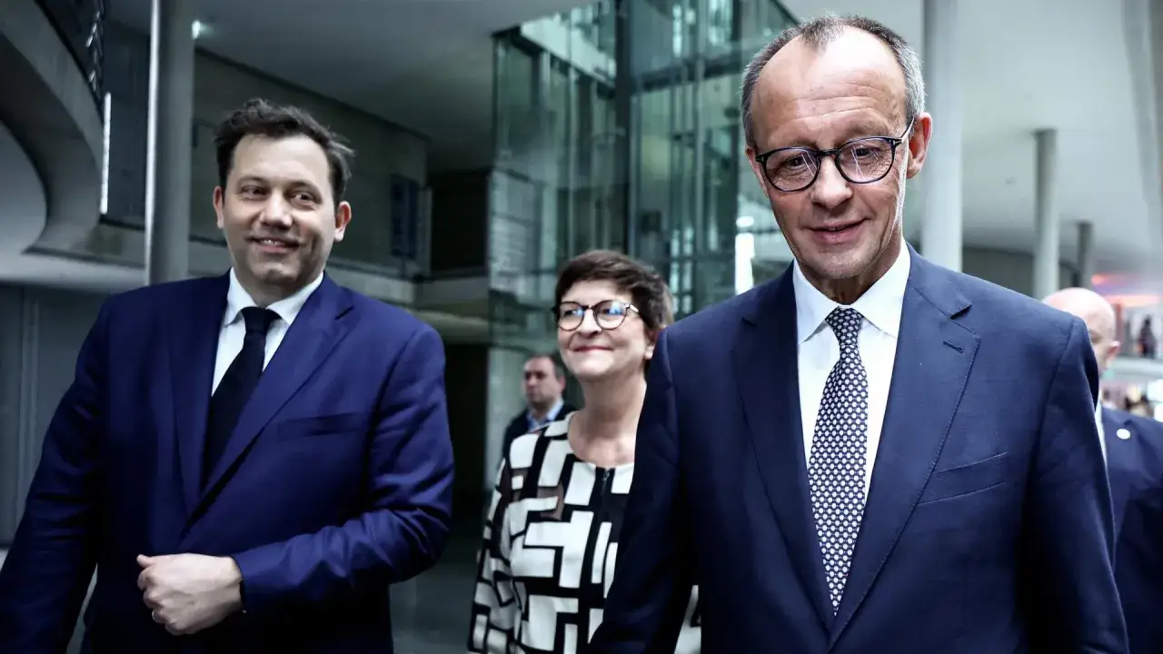 Drei Politiker, die &uuml;ber Koalitionsparteien sprechen, gehen durch einen modernen Geb&auml;udekomplex.