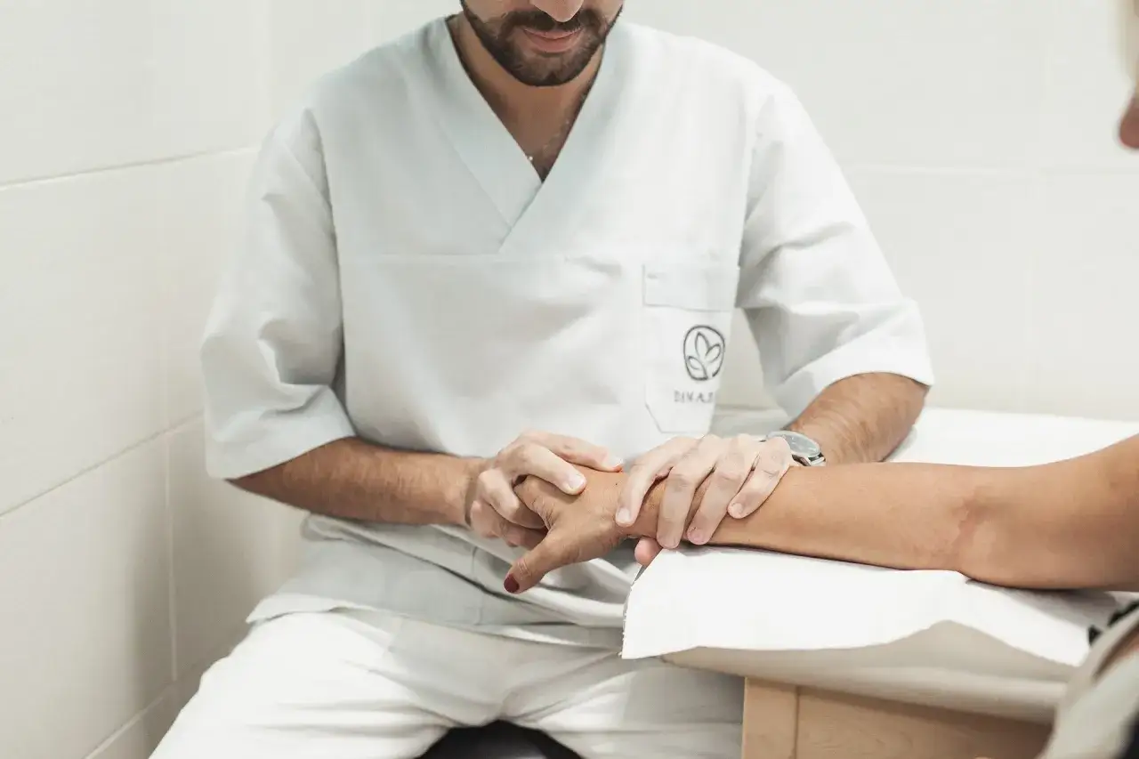 Fisioterapista esegue esercizi per dolore al polso su un paziente.