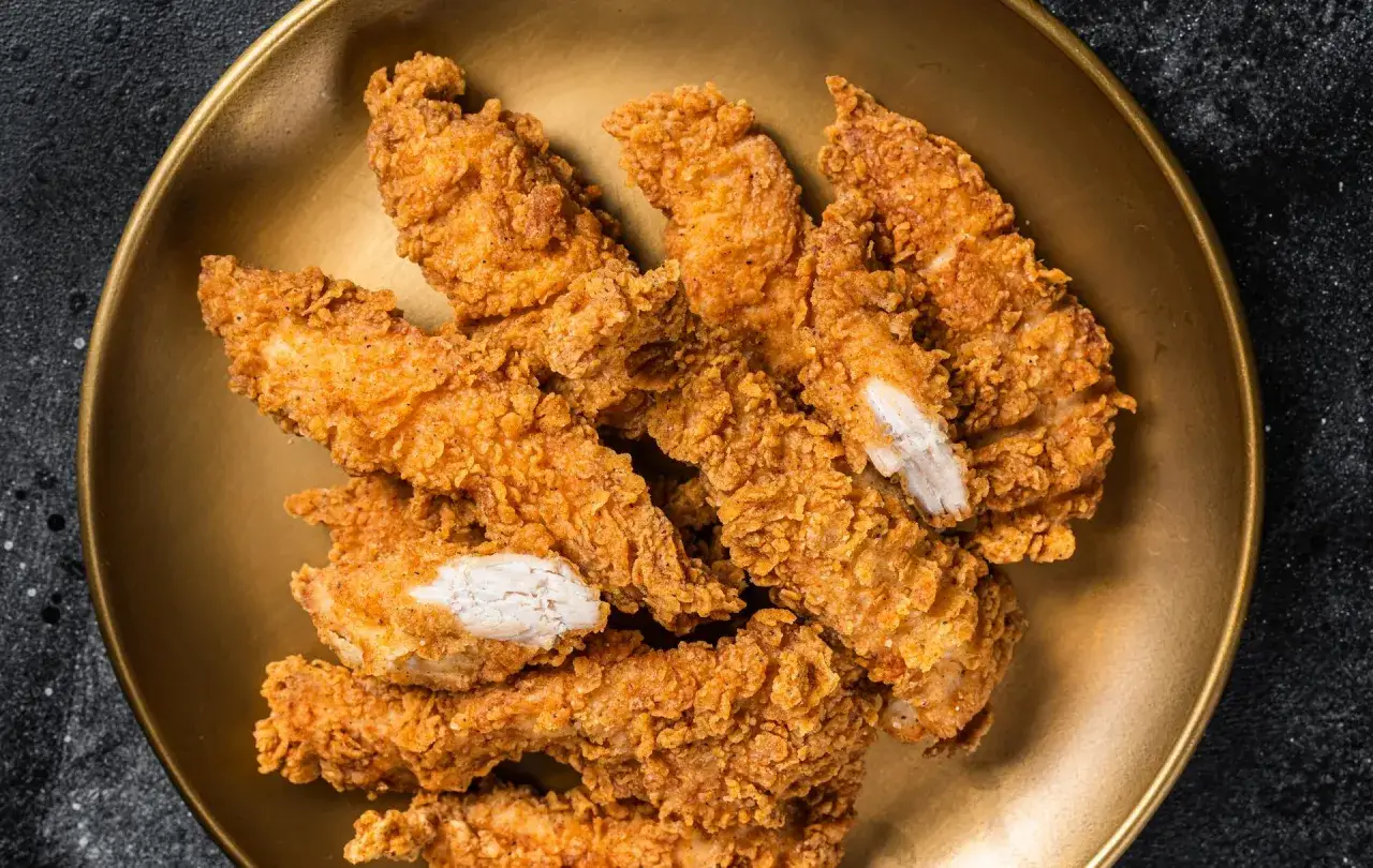 Une assiette dorée déborde de délicieux poulet pané croustillant, prêt à être dégusté.