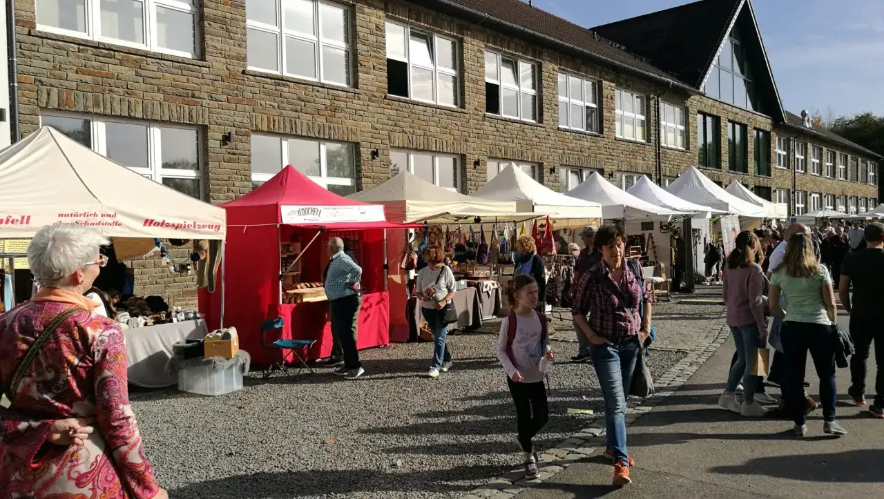 Markt in Lindlar: Was geht ab? Menschen bummeln an St&auml;nden mit Holzspielzeug und Handgemachtem vorbei.