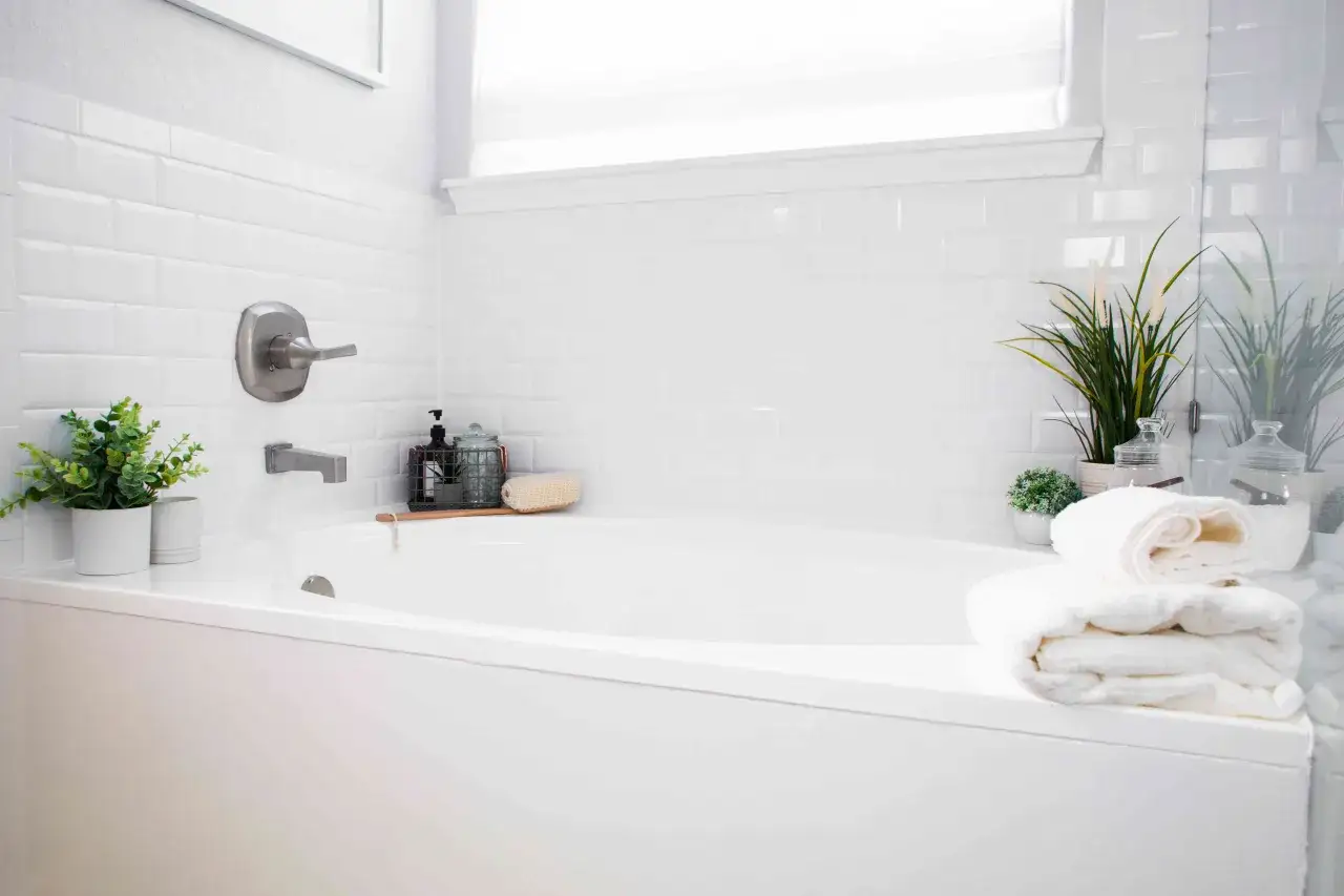 A clean white bathtub with subway tile walls, ready for a relaxing soak. This image shows how to paint a bathtub with fresh, bright results.