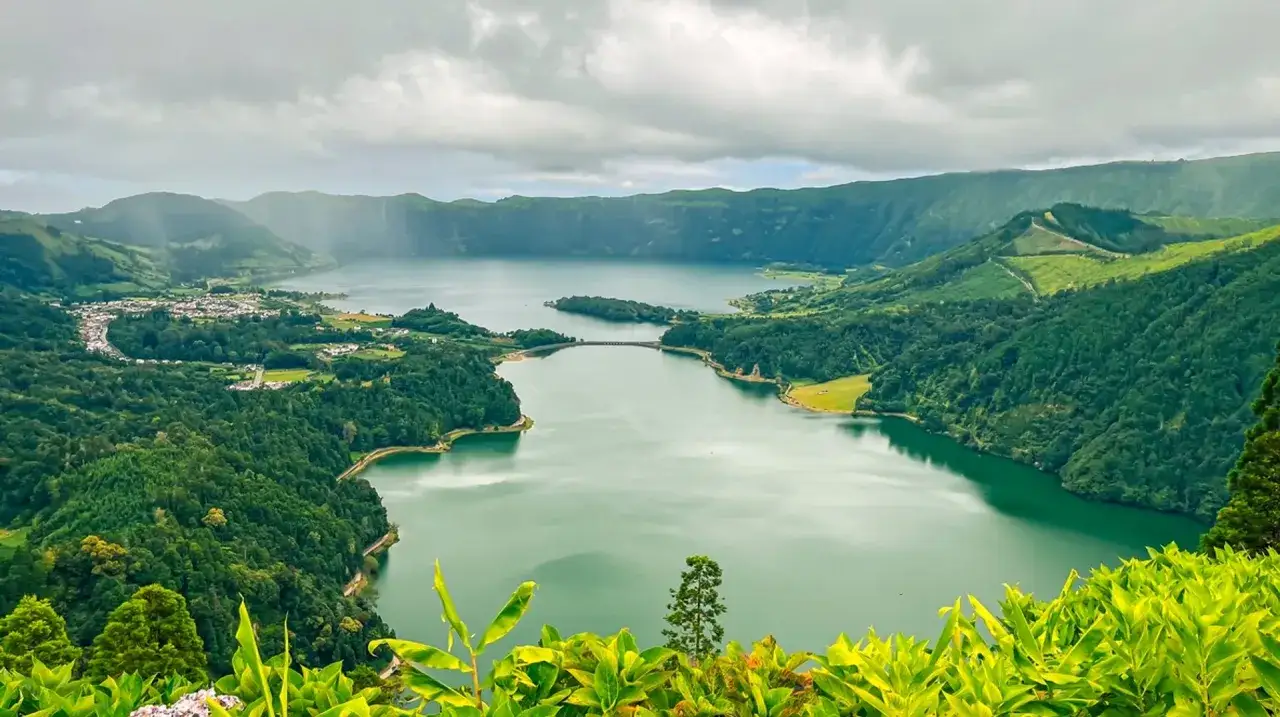 Grüne Vulkanlandschaft mit See und Brücke. Die Azoren sind ein Traumziel, die beste Reisezeit ist im Frühling/Sommer.
