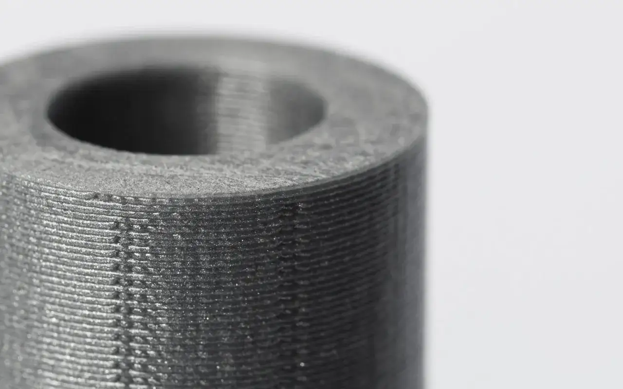 Close-up of a cylindrical object, showcasing the layered texture of precision 3D printing.