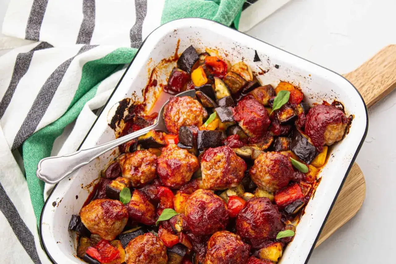 Un plat réconfortant de boulettes de viande barbecue, enrobées d'une sauce savoureuse, mijotant avec des aubergines et des poivrons rôtis.