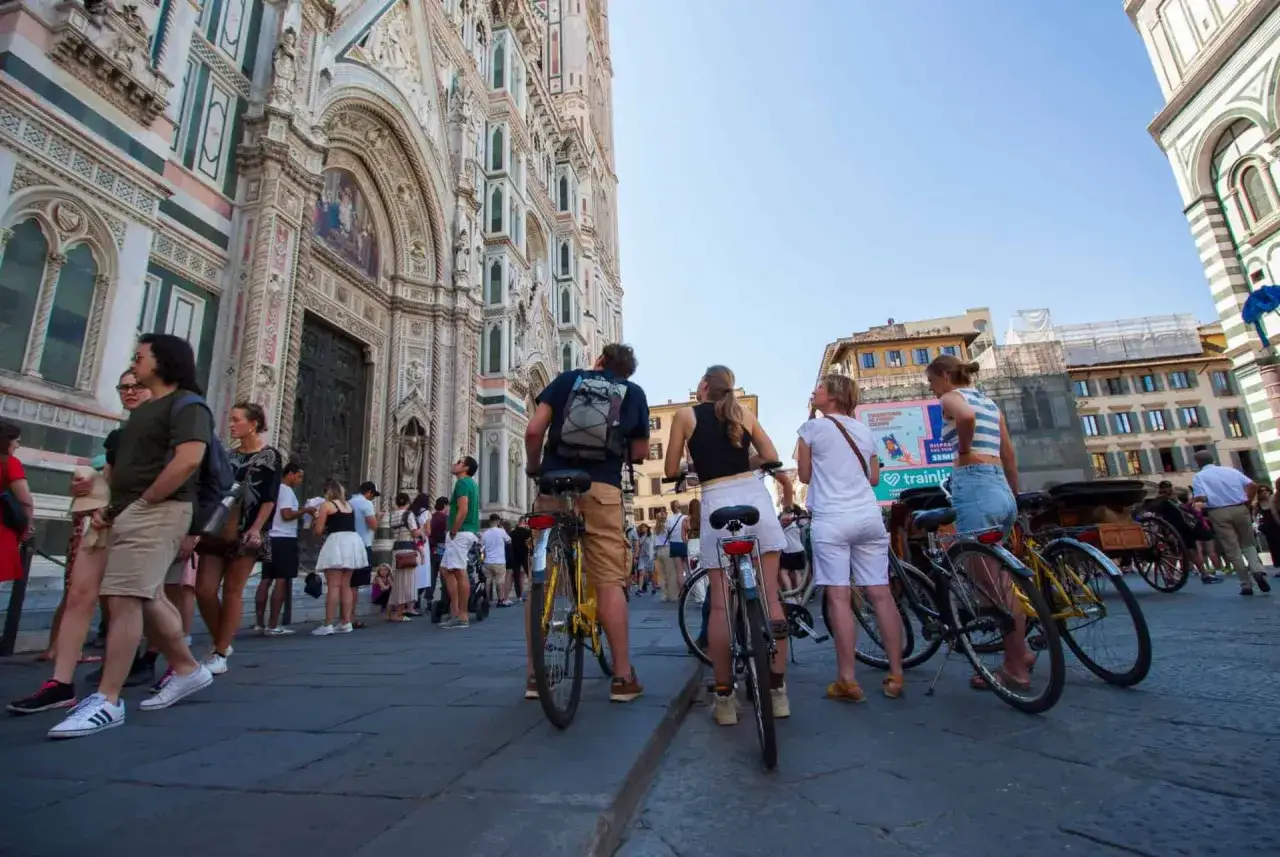Des touristes à vélo devant le Duomo de Florence. Un groupe explore la ville en vélo, profitant de la beauté de Florence.