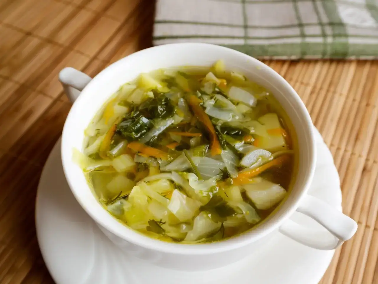 Aromaticzny kapuśniak z młodej kapusty, ziemniaków i marchewki, ozdobiony świeżym koperkiem. Idealny na wiosenny obiad.