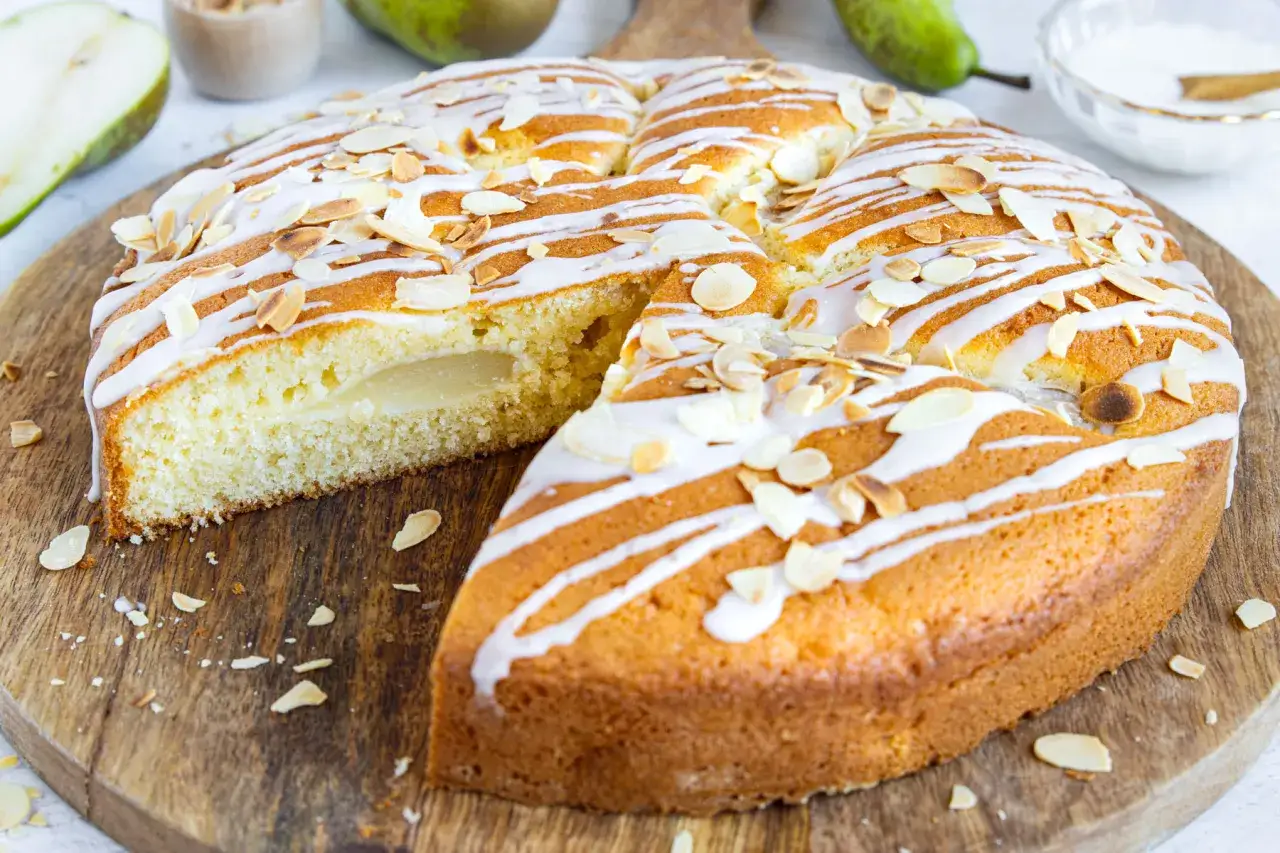 Saftiger Birnenkuchen mit Zuckerguss und Mandeln, perfekt f&uuml;r ein einfaches Birnenkuchen Rezept.