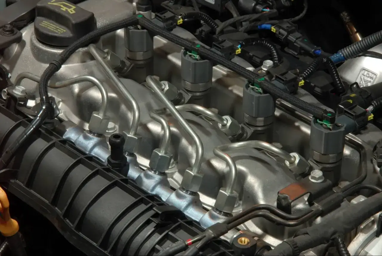 Gros plan sur le syst&egrave;me d'injection d'un moteur de voitures thermiques, avec ses injecteurs et ses conduites de carburant.