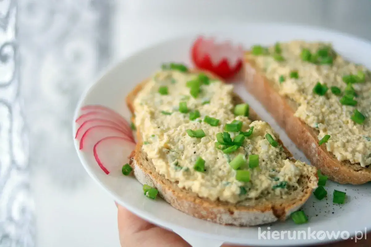 Pyszna pasta jajeczna jak dawniej, na chlebie żytnim, ozdobiona szczypiorkiem i rzodkiewką. Smak dzieciństwa!