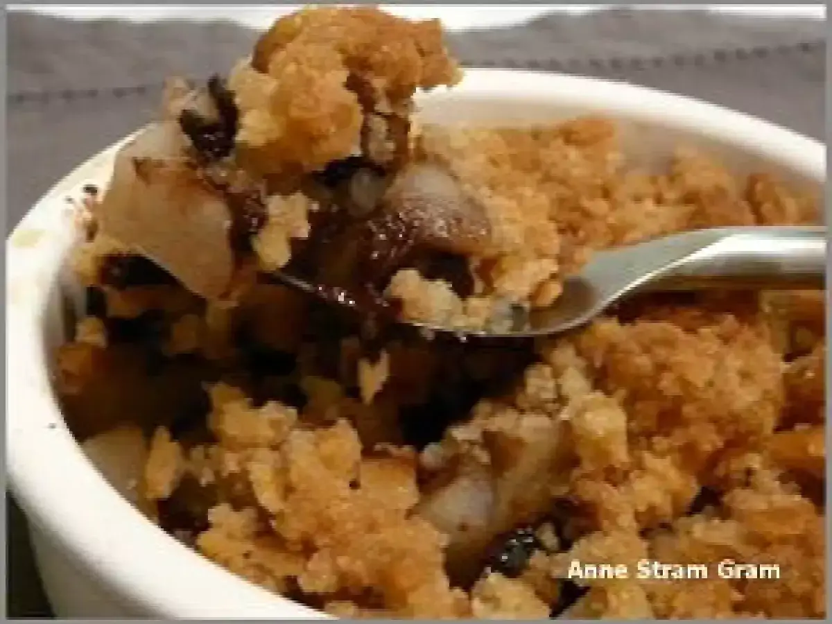 Cuillère prélevant un morceau d'un délicieux crumble poire chocolat, avec des morceaux de poire fondante et de chocolat noir.