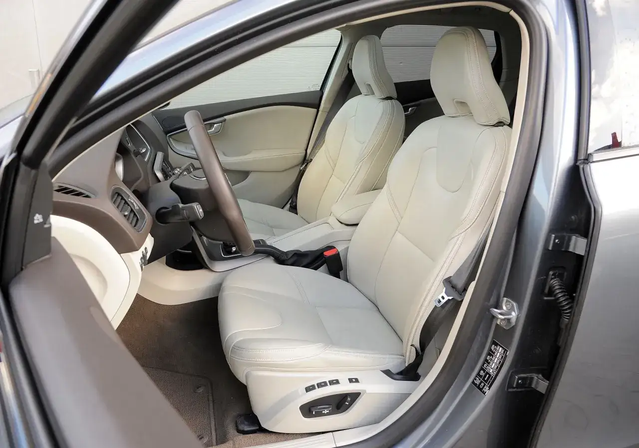 Jasne, oto opis alternatywny:
Wnętrze Volvo V40 z jasnymi, skórzanymi fotelami. Kierownica i deska rozdzielcza w ciemniejszych odcieniach. Wiele osób chwali sobie komfort i jakość wykonania, co potwierdzają liczne volvo v40 opinie.