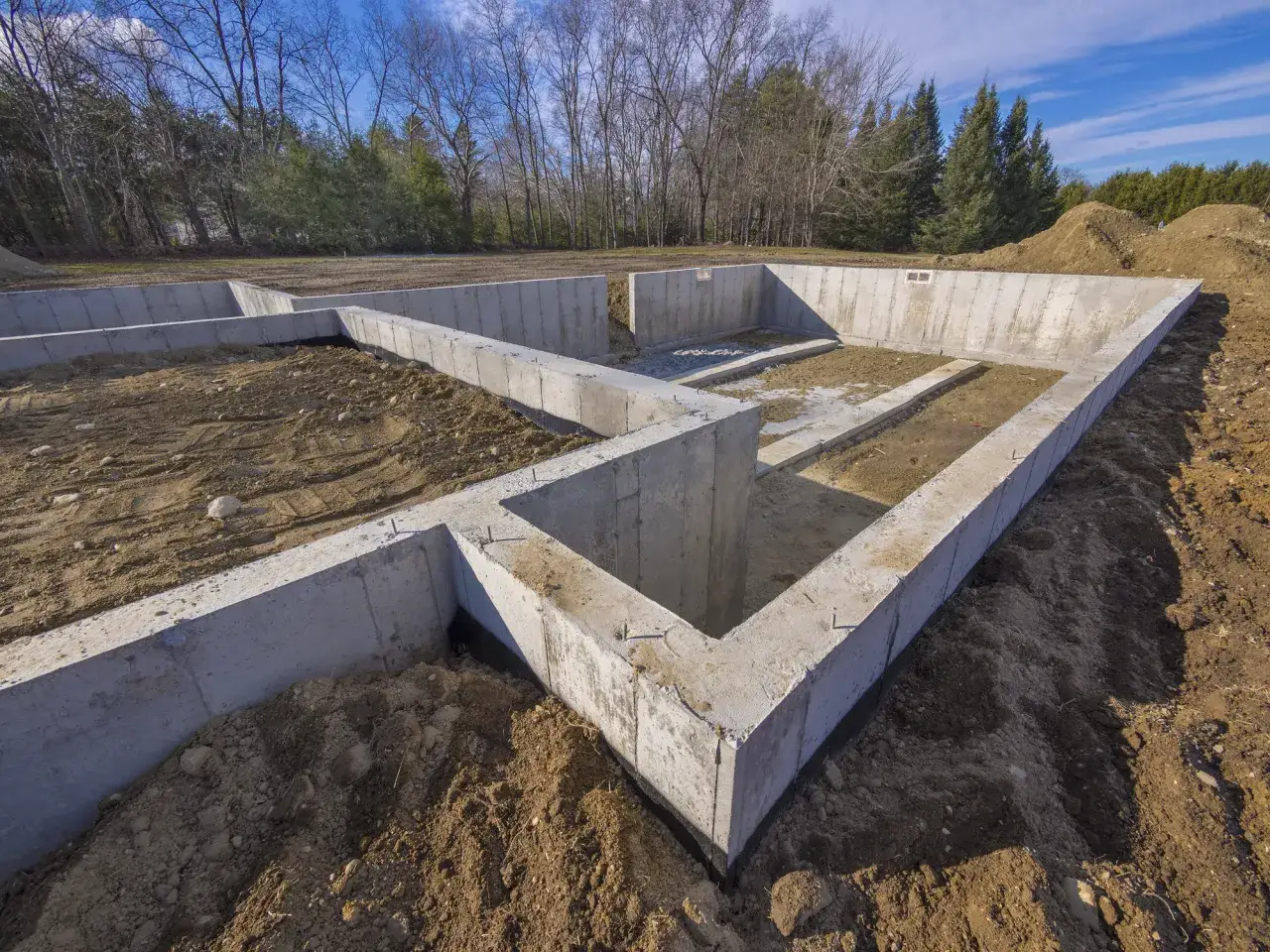 Betonowe fundamenty domu w budowie. Zastanawiasz się, ile kosztuje wylanie fundamentów? To pierwszy krok do Twojego wymarzonego domu.