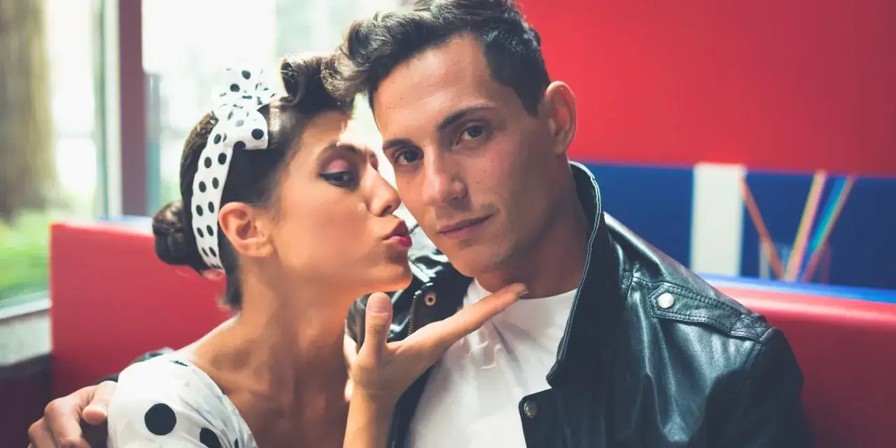 Couple au style rockabilly, elle lui fait un clin d'&oelig;il, lui porte une veste en cuir.