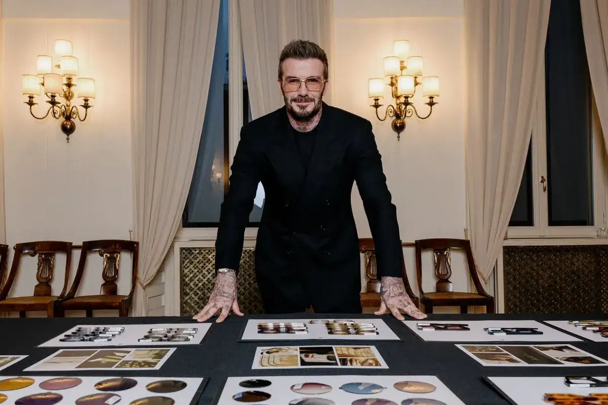 David Beckham i hans ikoniska david beckham style, med tatueringar och glasögon, presenterar sina senaste designerprodukter.