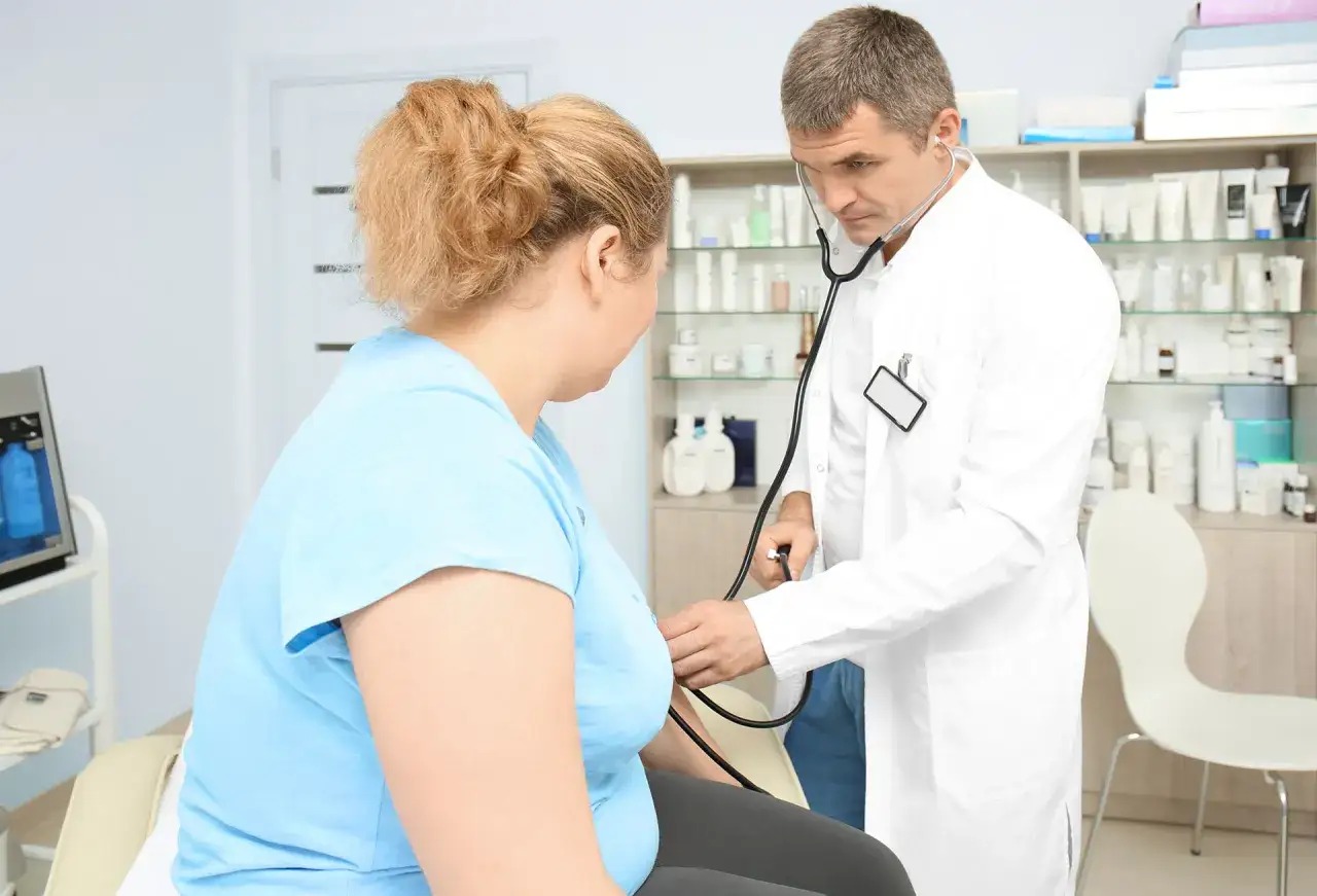 Lekarz bada pacjentkę, która chce dowiedzieć się, jak zakwalifikować się do operacji bariatrycznej na NFZ.