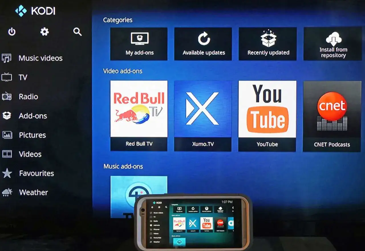 Udostępnianie ekranu z telefonu na telewizorze z aplikacją KODI. Widoczne ikony Red Bull TV, Xumo.TV, YouTube, CNET Podcasts.