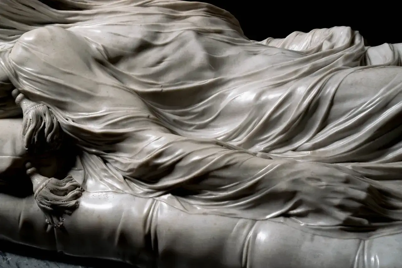 Dettaglio della scultura in marmo della Pudicizia a Napoli, con panneggio che avvolge un corpo.