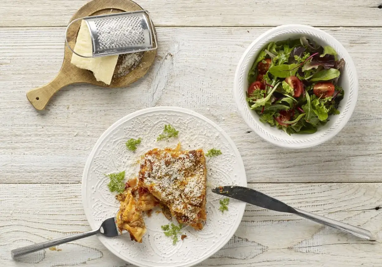 Lasagne z parmezanem i świeżą sałatką z pomidorkami. Idealny zestaw, by dowiedzieć się, co podać do lasagne.